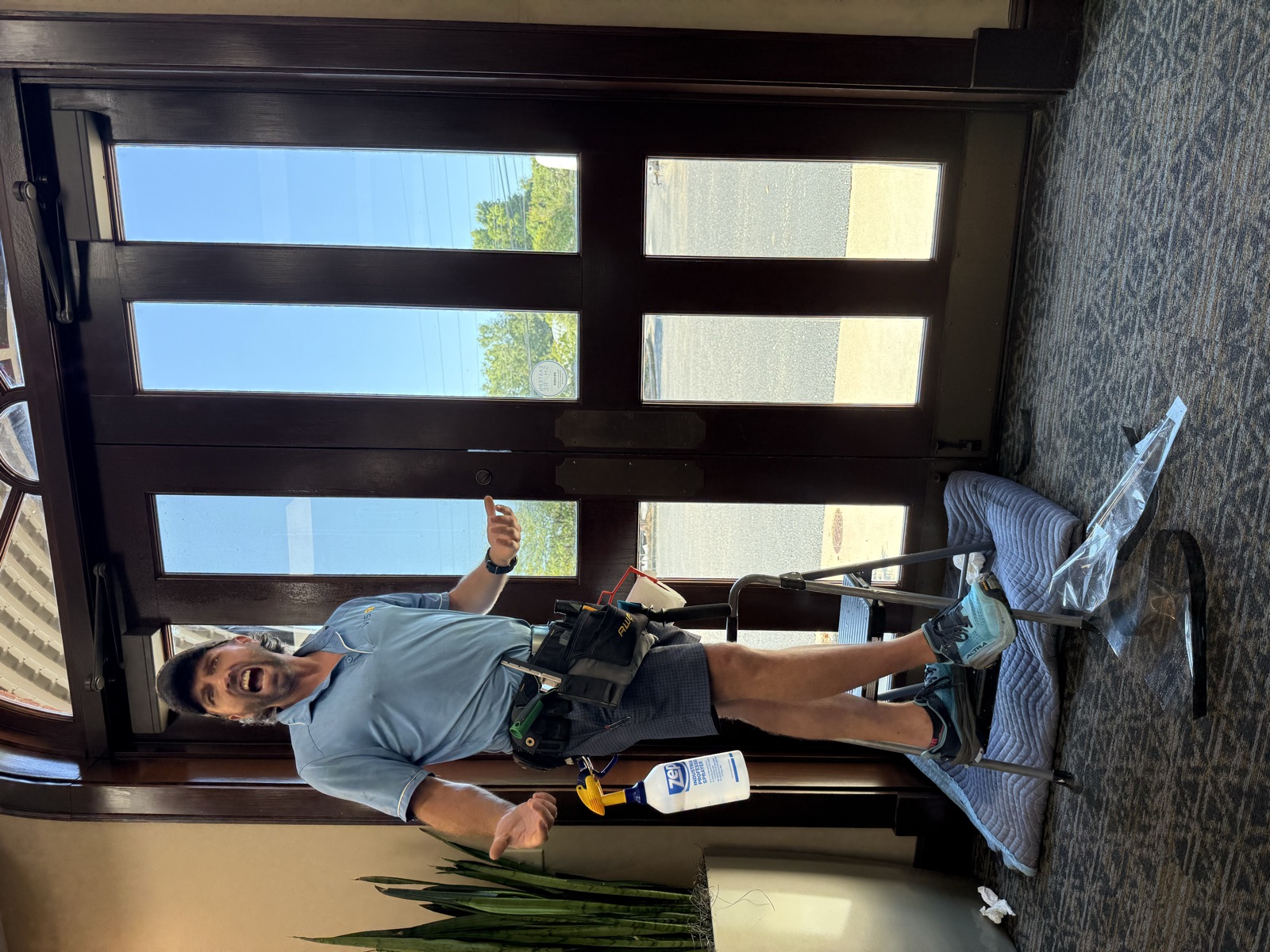 Joe with his tool belt at a commercial glass entry door in Mobile