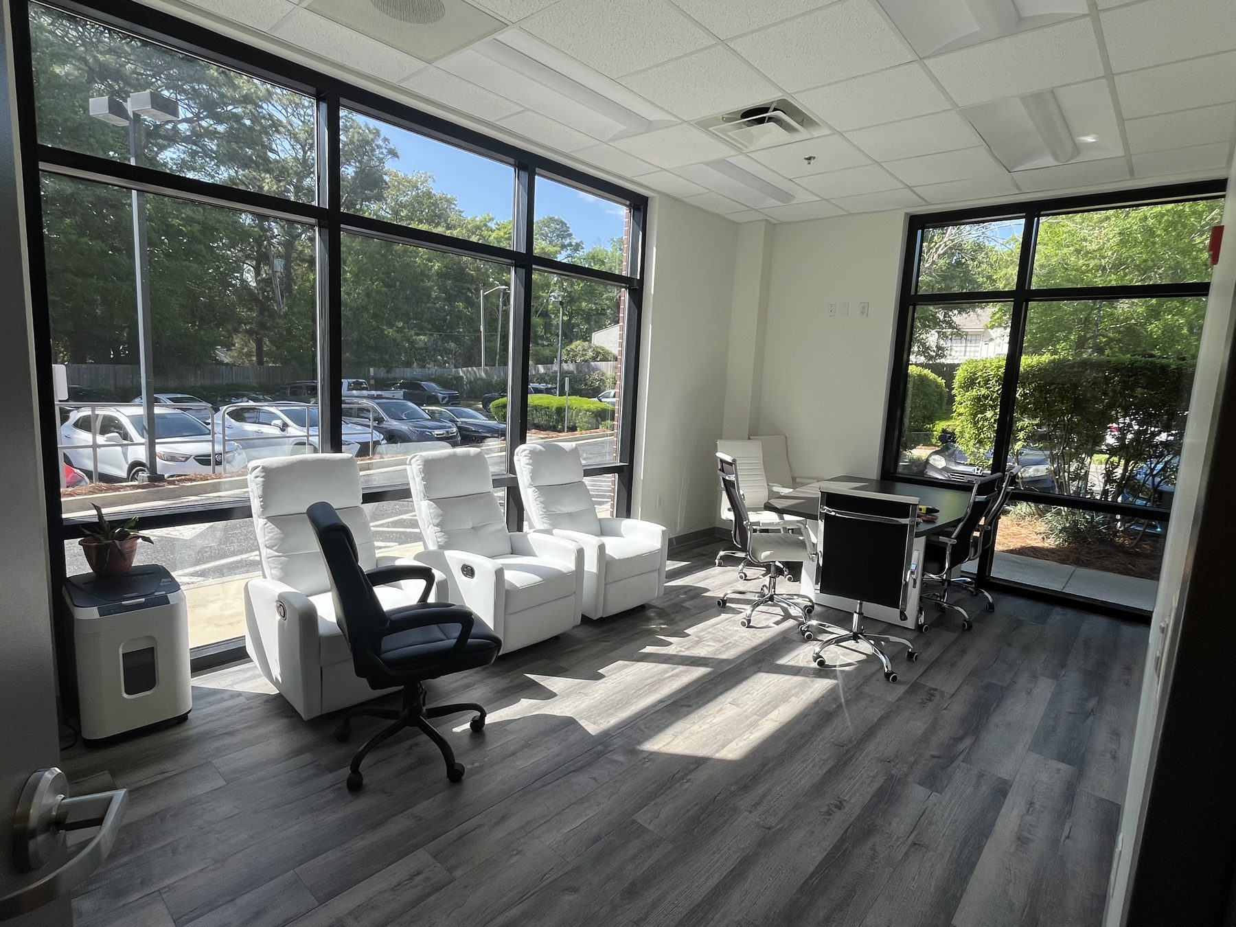 A corner office in Fairhope before film, with sun striping across the recliners